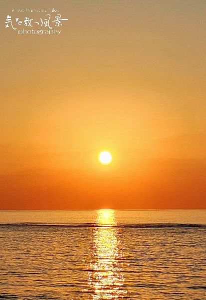 サンゴ礁と久高島の朝日 サンゴ礁と久高島の朝日