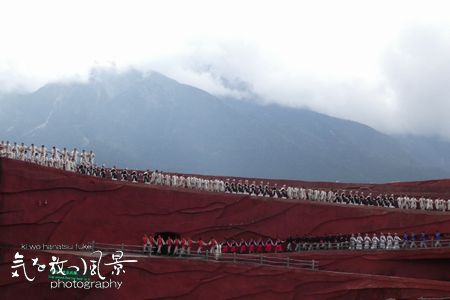 玉龍雪山の中腹の野外劇場での少数民族の歌劇 玉龍雪山の中腹の野外劇場での少数民族の歌劇